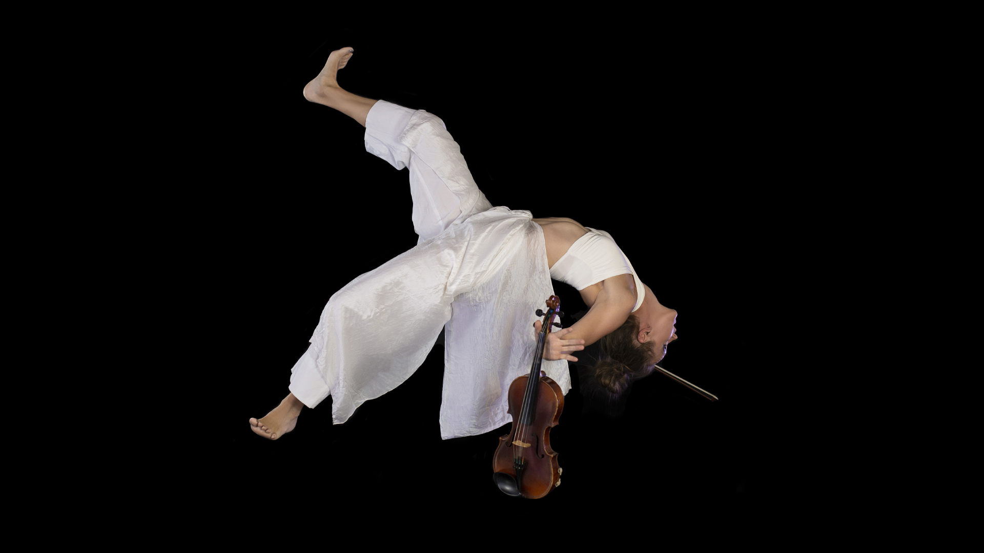 A person hangs upside down holding a violin.