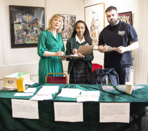 3 people pose by a table
